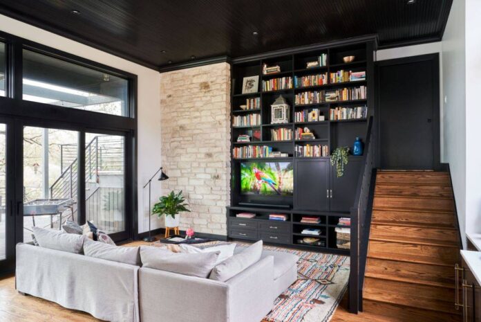 Entertainment wall coupled with bookshelves and exposed brick wall section in the stylish family room