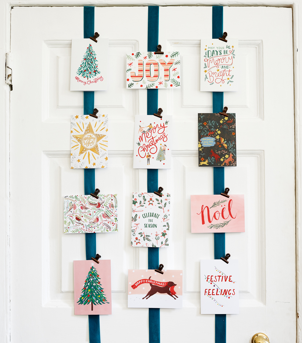 Christmas cards hung on ribbons on the back of a door