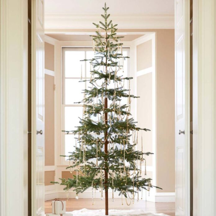 sparse asymmetric christmas tree in a pink room
