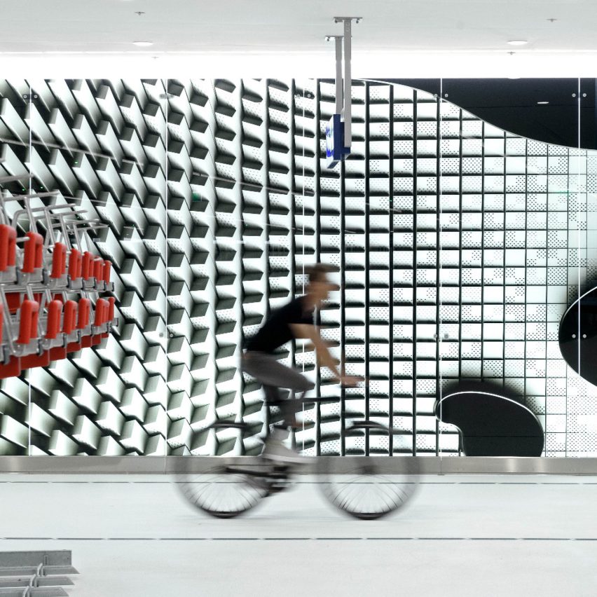 A man cycling next to a bike rack