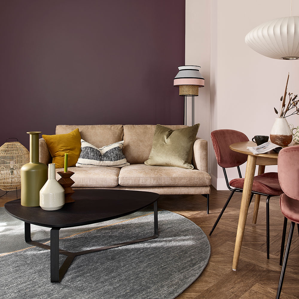 Small living room with burgundy feature wall camel sofa and grey rug