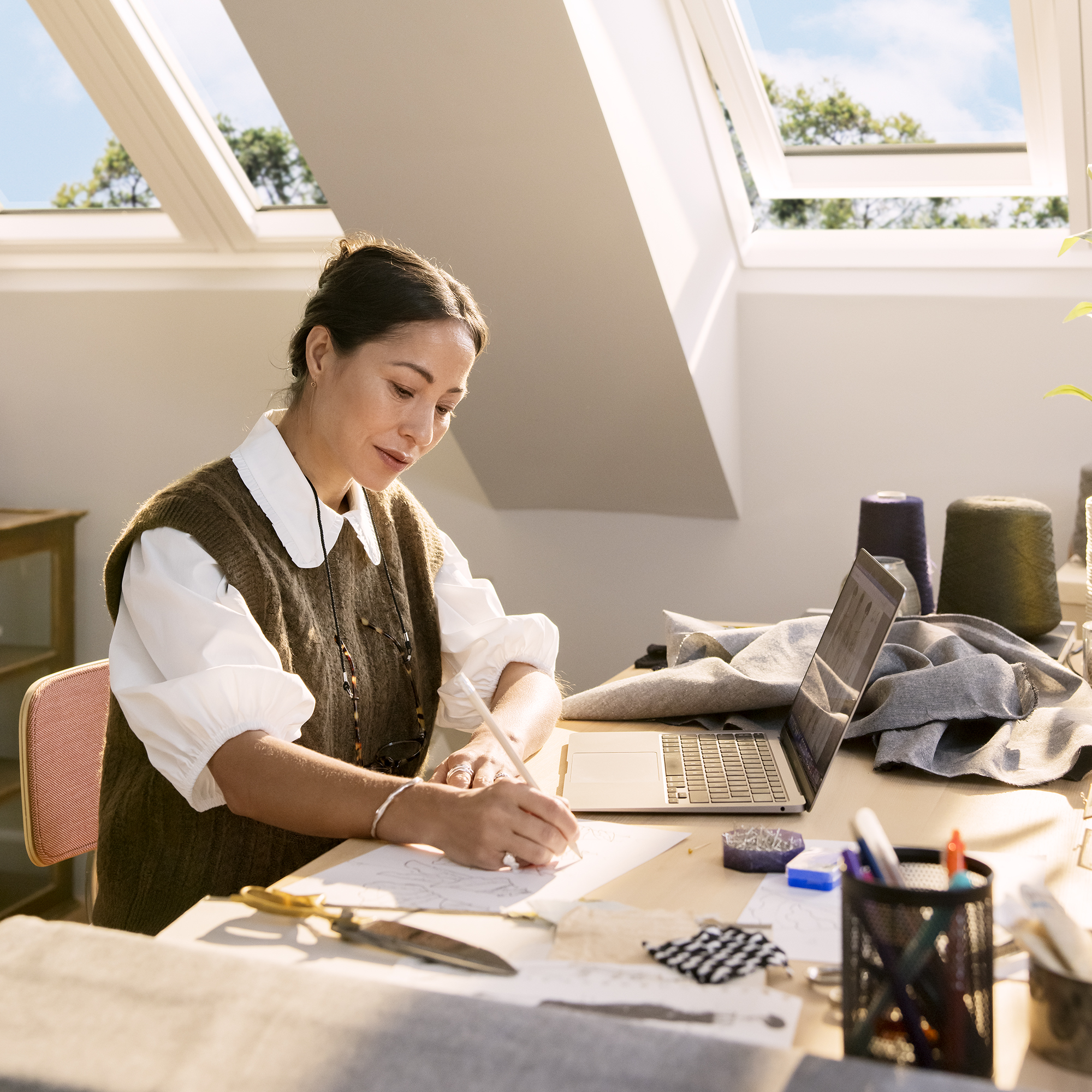 woman working at a desk with open roof lights