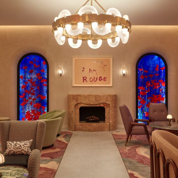 Interior of The Red Room bar in The Connaught hotel, London with stained-glass panels by Brian Clarke framing a marble fireplace