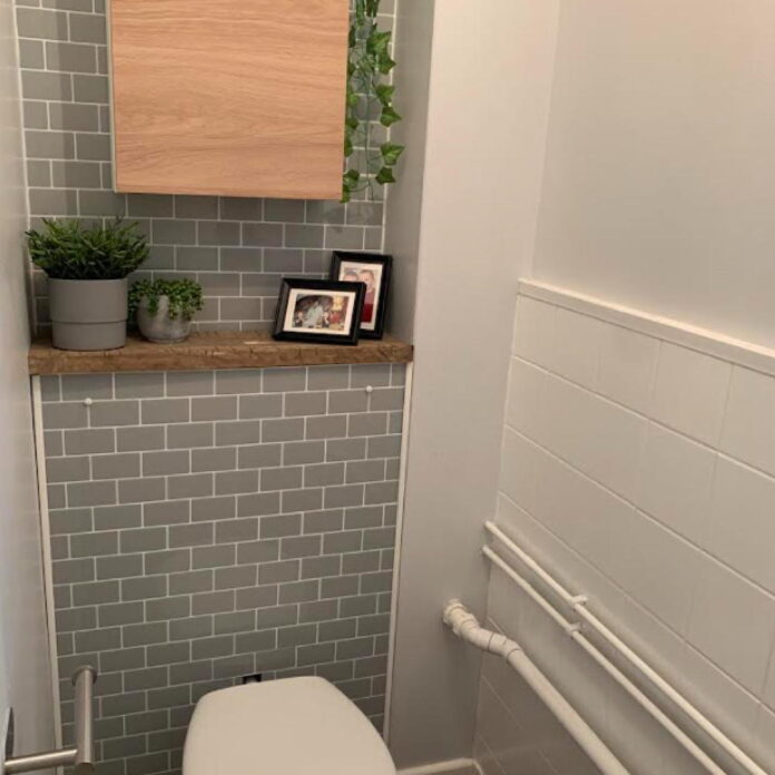 small downstairs toilet with sage green wall tiles