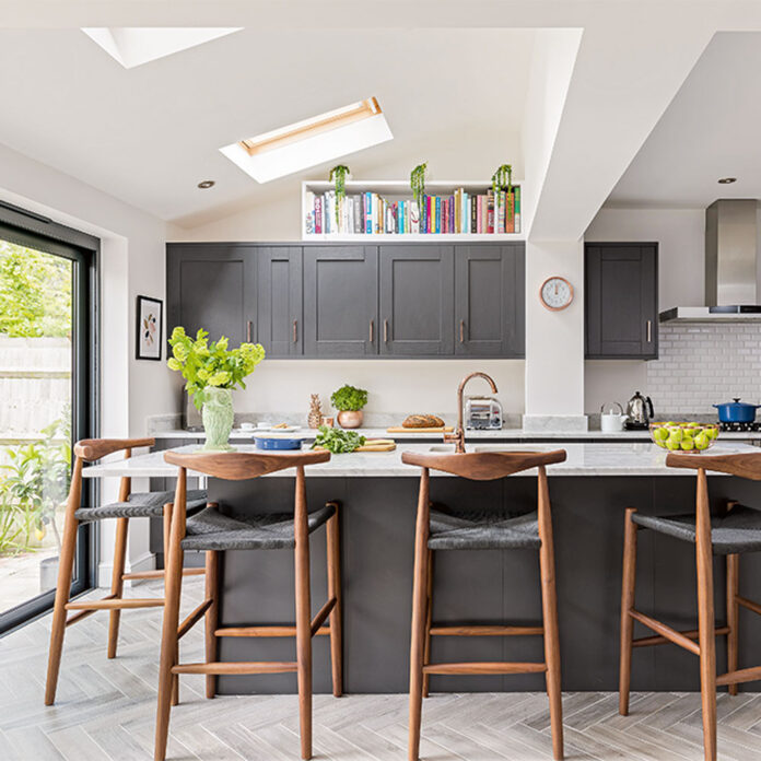 Black and white kitchen with black cabinets white walls and wooden stools