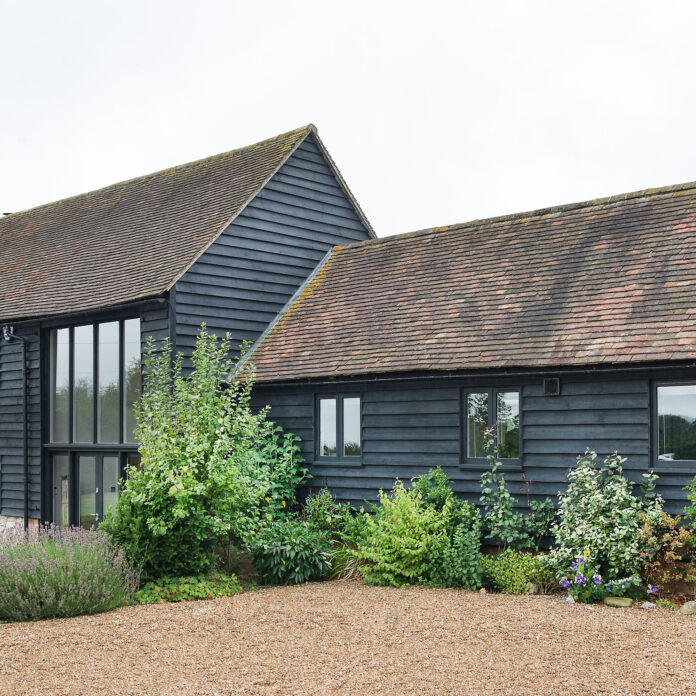 Dark grey barn conversion with naturalistic border