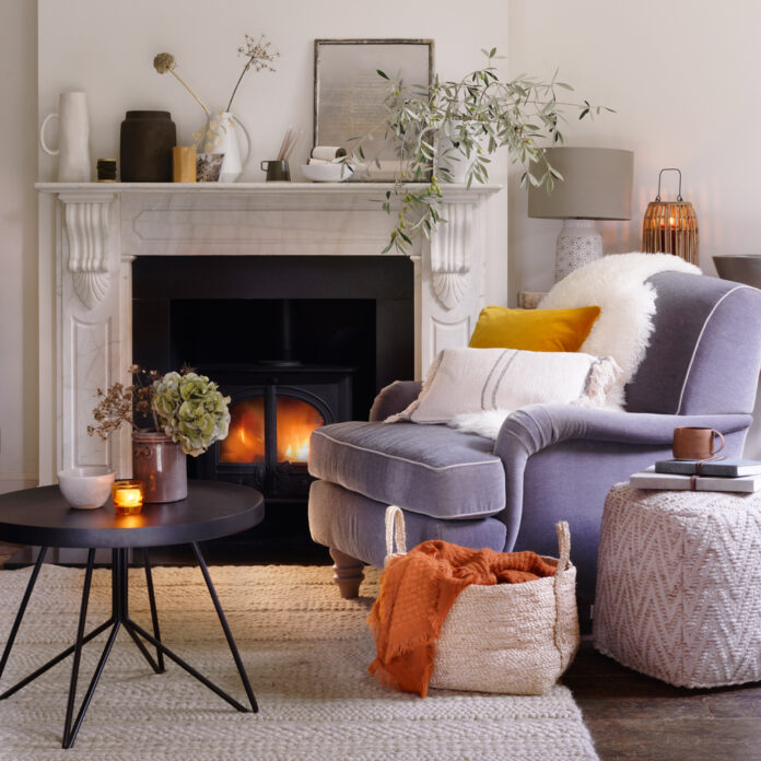 neautral living room with cosy fireplace and grey armchair