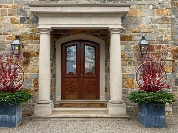 Two large container gardens on either side of a front entrance