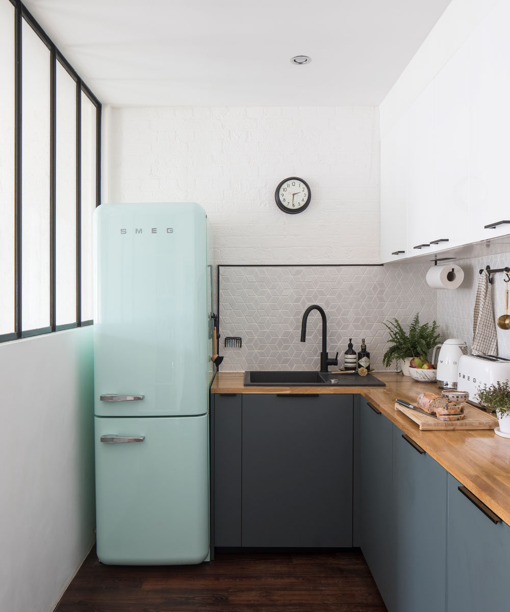 compact kitchen with mint green fridge and grey and white units