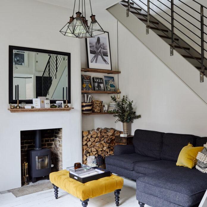 A mono sitting room with mustard accents and a dark blue sofa