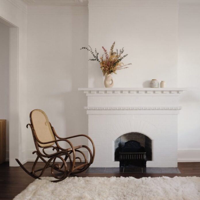 A rocking chair in front of an original fireplace in Montreal home