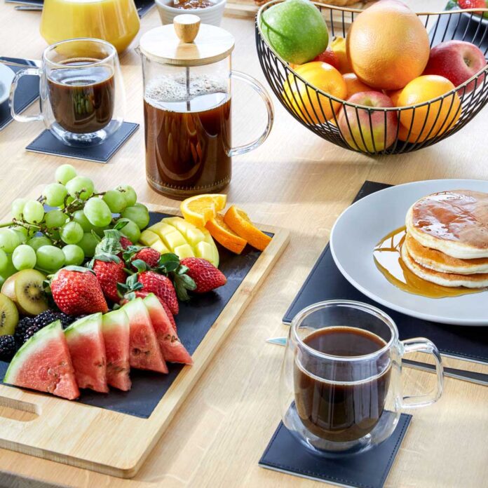 glass coffee mugs from poudland on table of fruit and pancakes