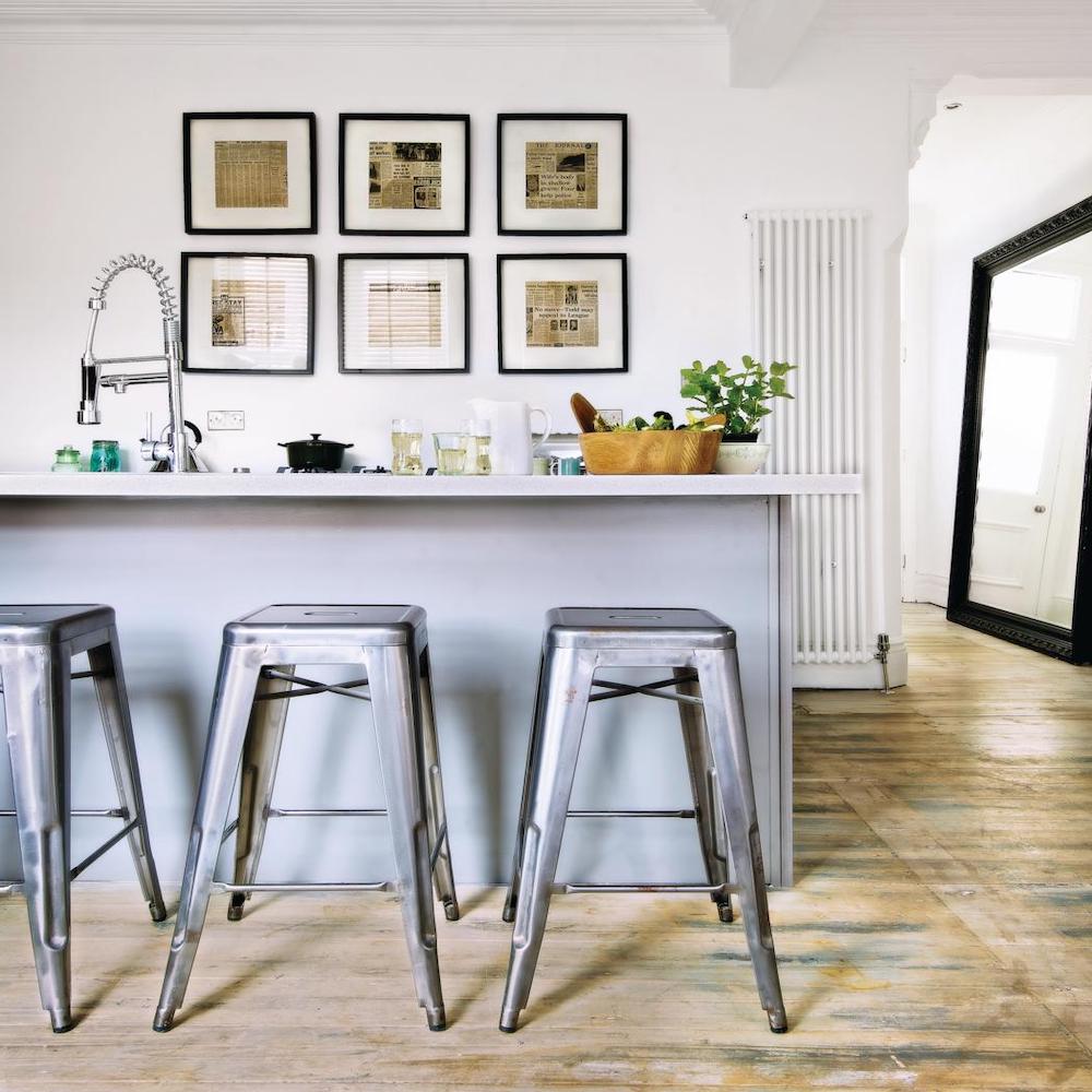 Blue kitchen island with metal bar stools