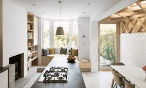 an open plan kitchen diner with bay window seat and striking timber lattice work on wall and ceiling