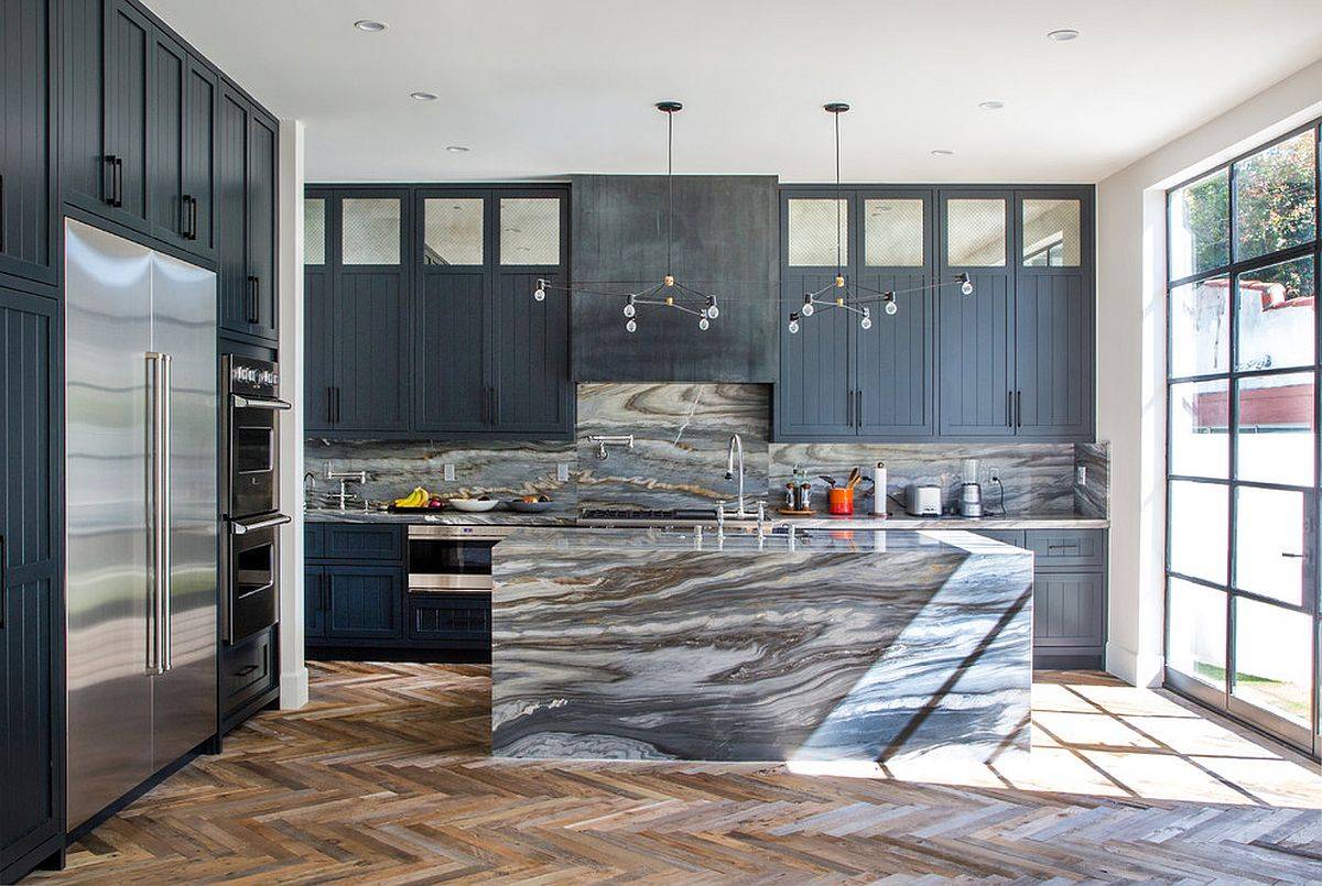 Captivating stone finishes fashion both the island and the backdrop in this kitchen