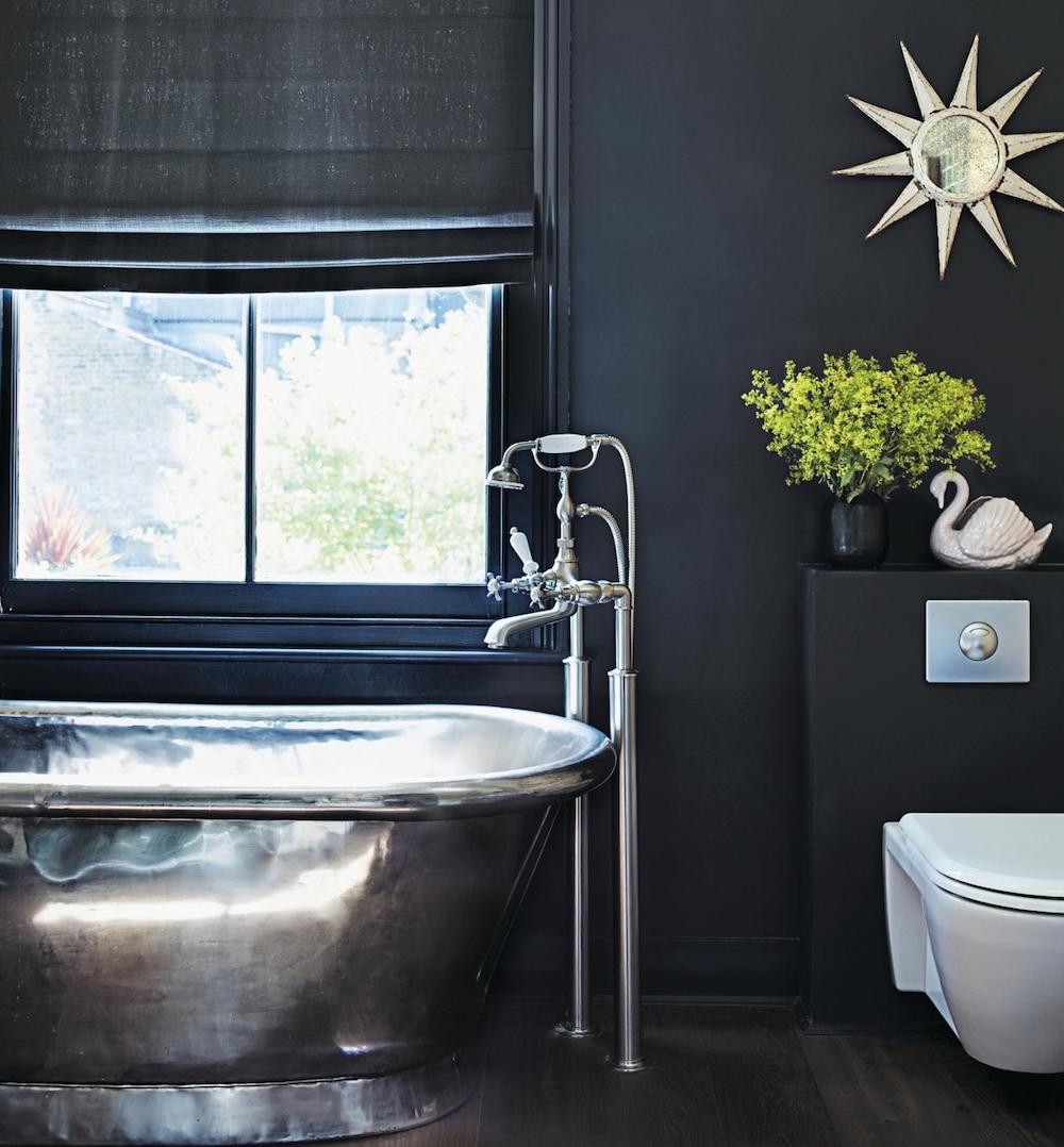 Black bathroom with stainless steel freestanding bath