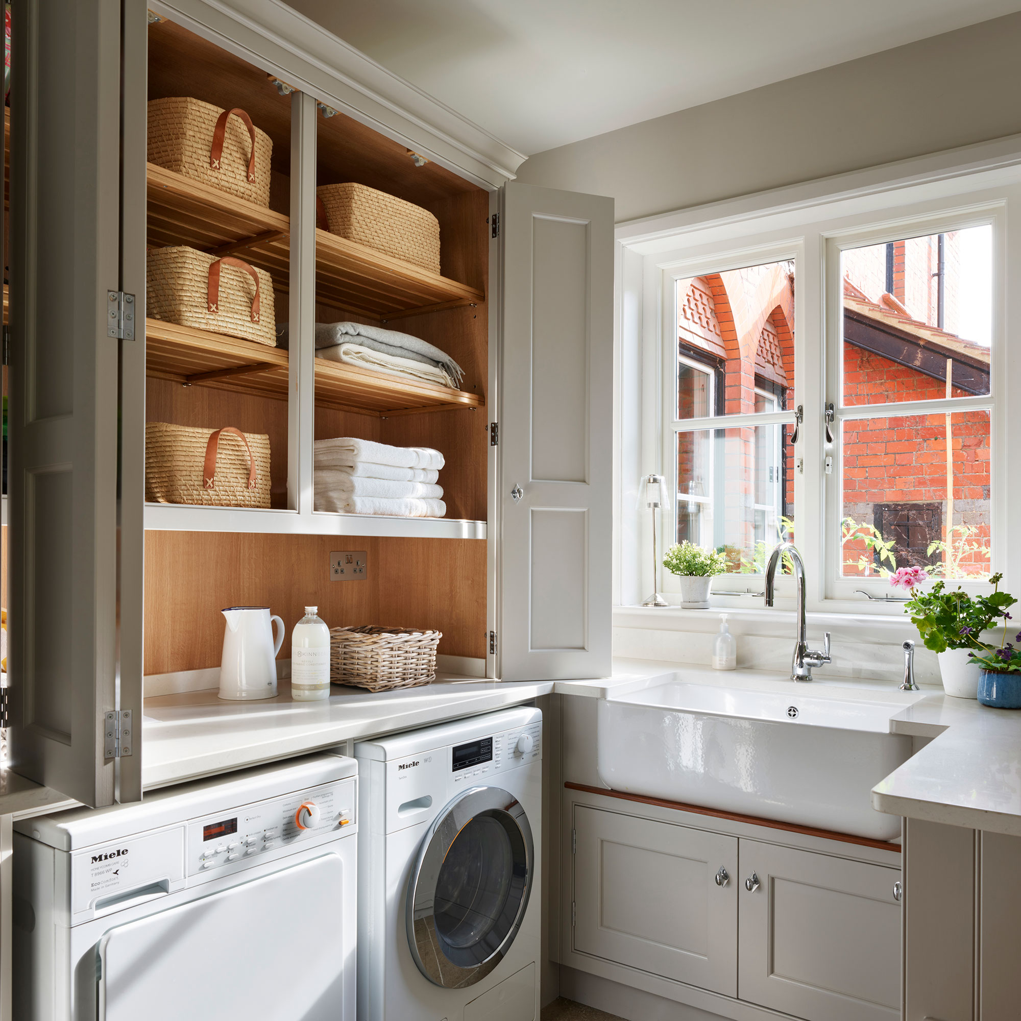 Grey utility room with appliances, sink and storage