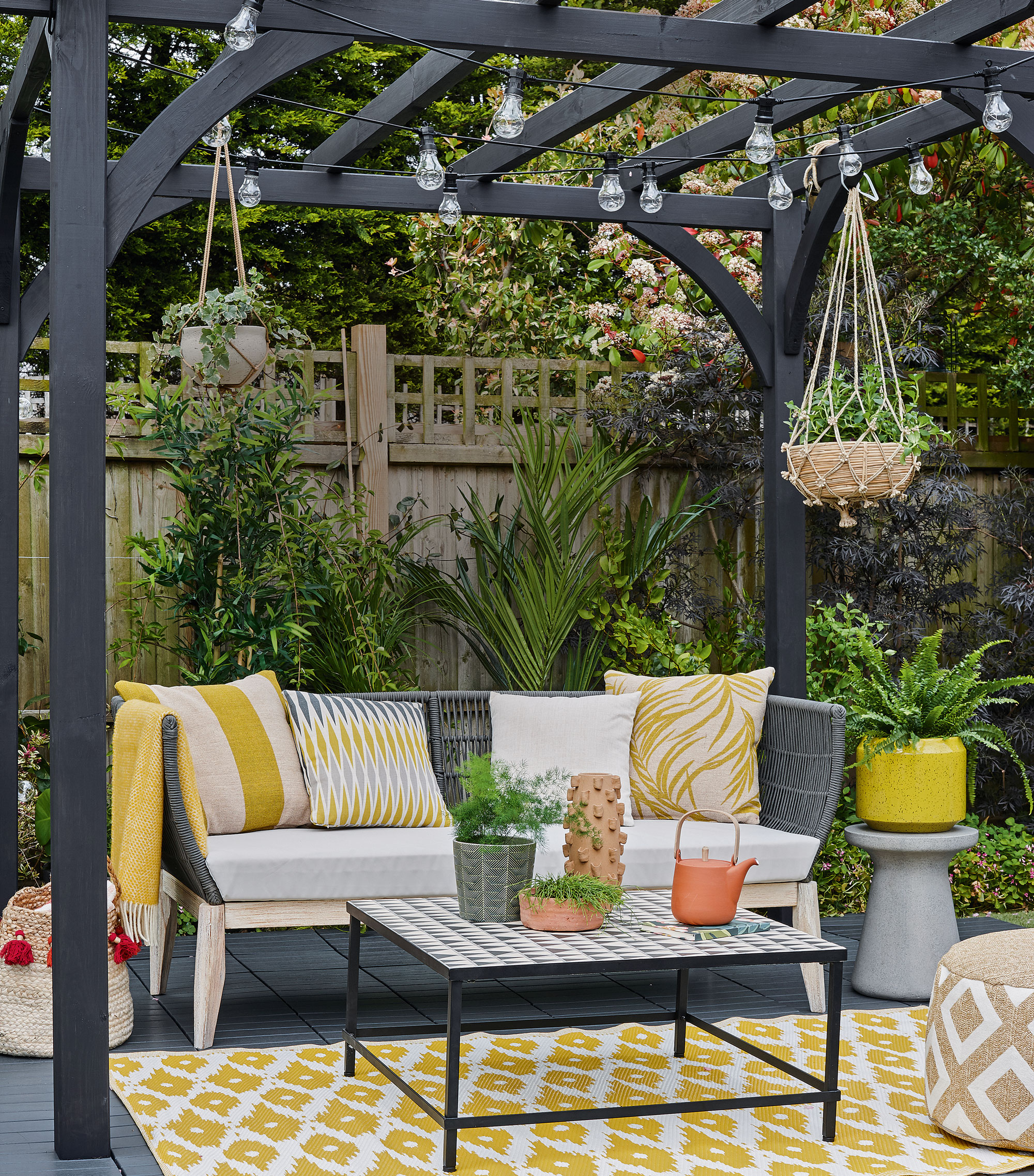 outdoor patio with pergola painted slate grey with string of festoon lights