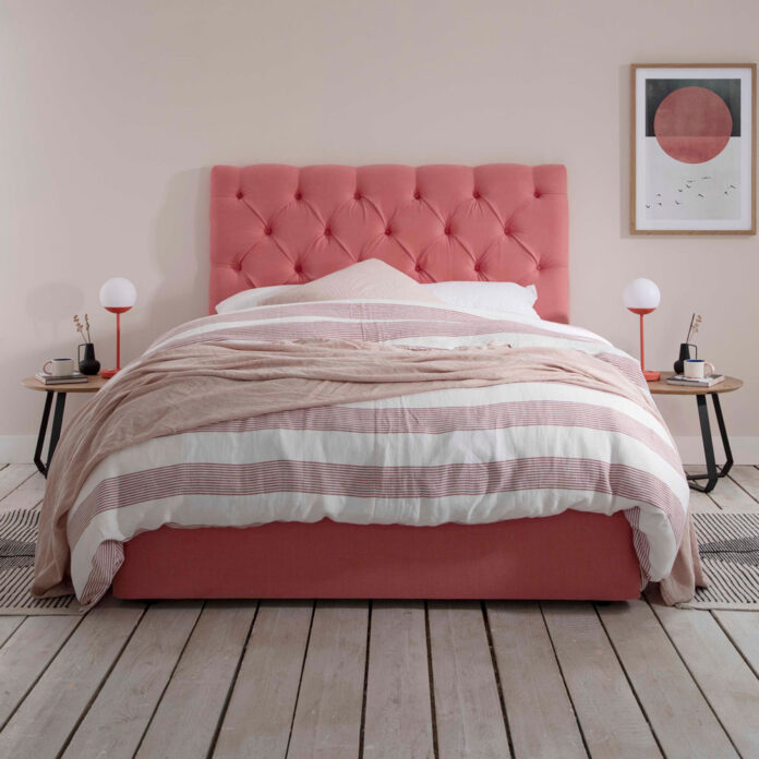 pink bed with large headboard, pink bedside lamps and striped bedding