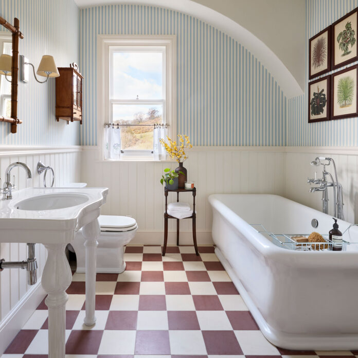 Bathroom with white and burgundy chequerboard floor and white bath and sink