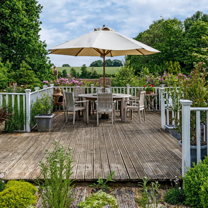 Garden terrace with sun umbrella. New England Style renovation