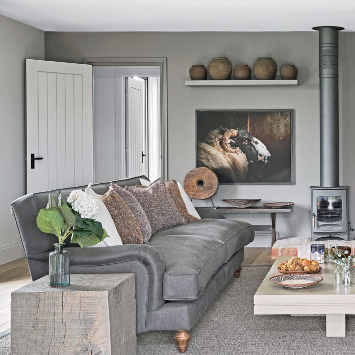 Grey living room with sofa, woodburner and brown details
