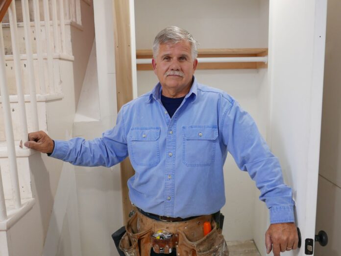 Tom Silva works on trimming a door.