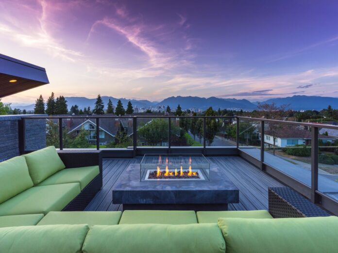 A rooftop deck with a firepit looking out to the mountains at sunset.