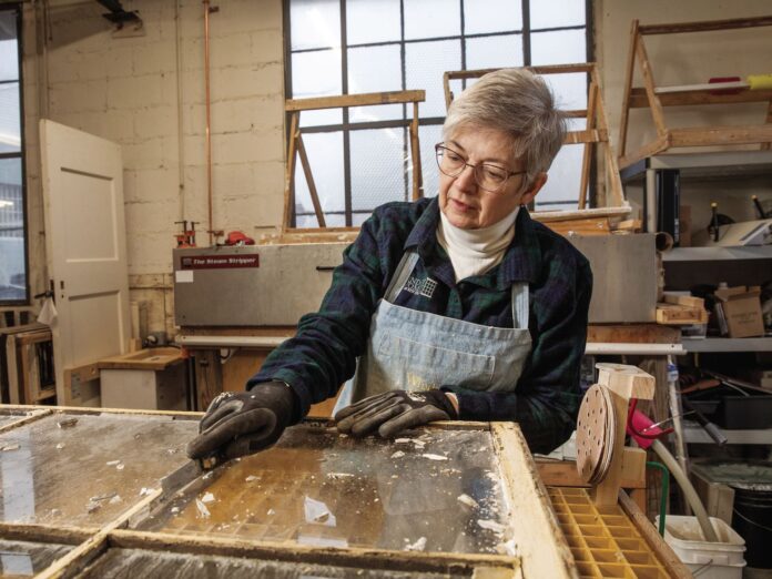 Alison Hardy removes old putty and paint from an antique window in her workshop. “A lot of times, people will look at old windows and say, ‘That’s too rotted; you can’t fix that,’ ” she says. “But most of the time, it’s just the paint that’s bad—once you get that off, you see how beautifully built they are.”