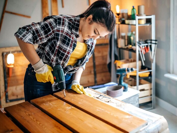 A woman constructing shelves in her garage