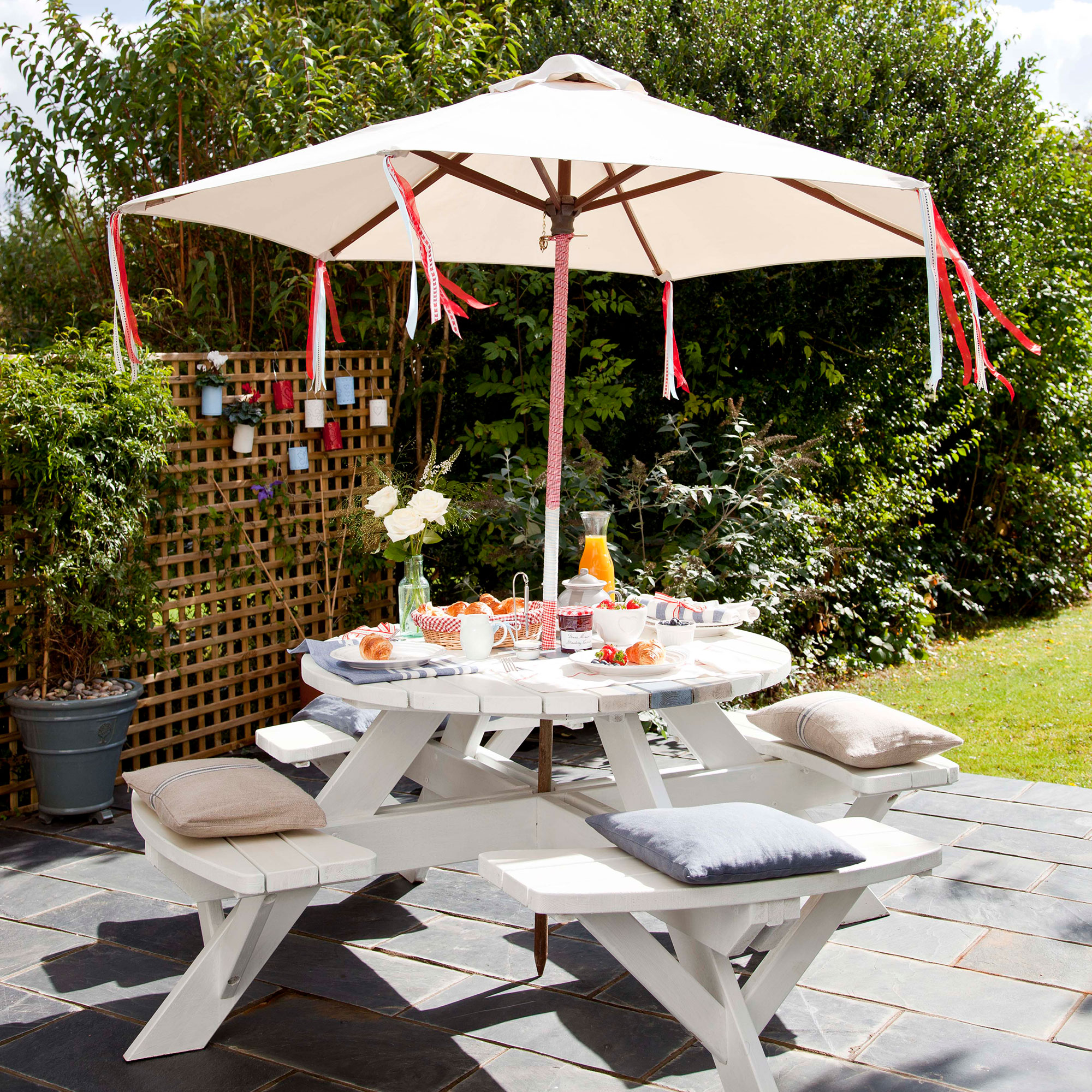 Round white garden table with parasol in midddle