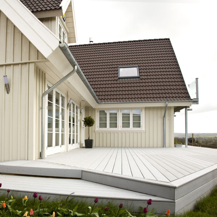 Exterior of weatherboard wooden detached house with raised decking 