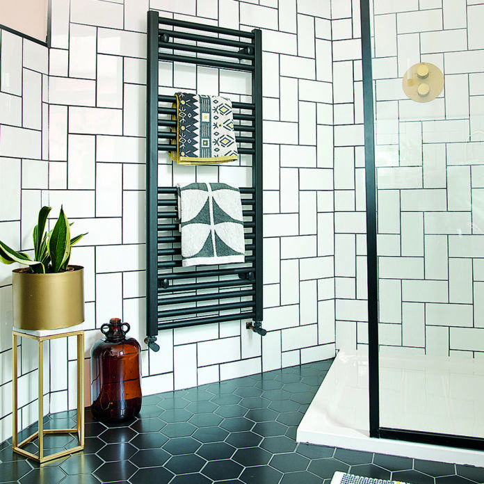 Monochrome bathroom with black hexagon floor tiles and white subway wall tiles in a herringbone pattern