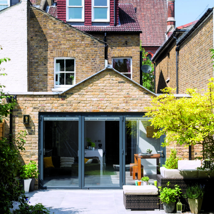 pitched roof rear extesion on a semi detached brick house with grey anthracite sliding doors