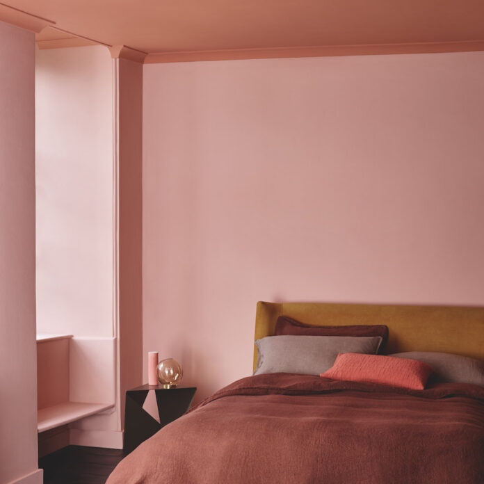 Pink and coral painted bedroom with painted ceiling. With ochre headboard and terracotta bedlinen