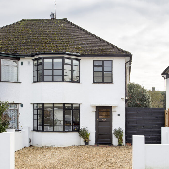 Semi-detached white house, pebble drive, black front door