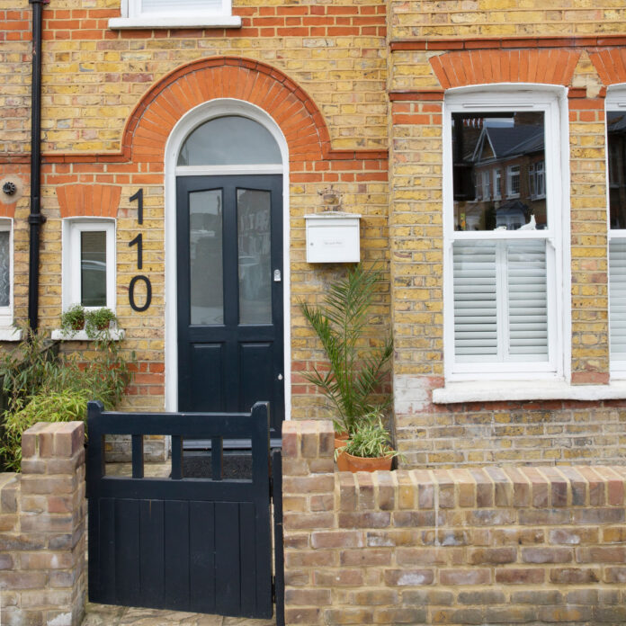 Red brick house exterior front door with matching black gate