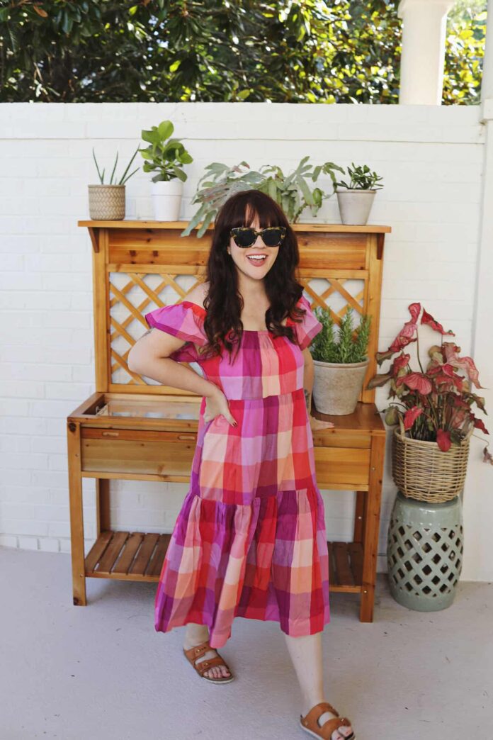 woman in dress standing in front of a potting station.