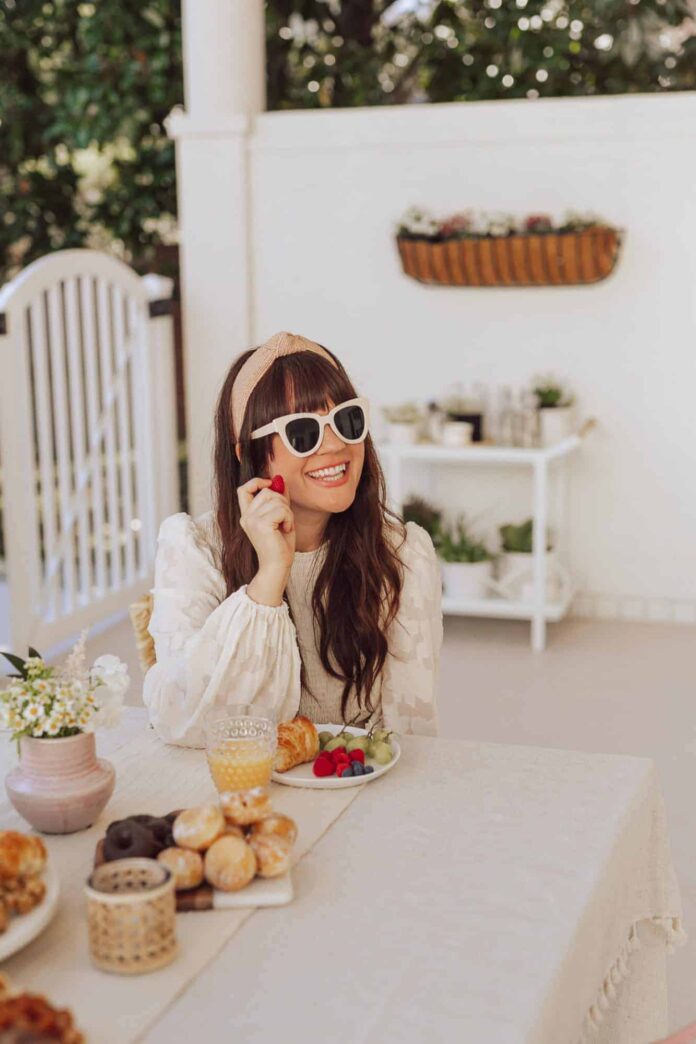 woman sitting at an outdoor table eating