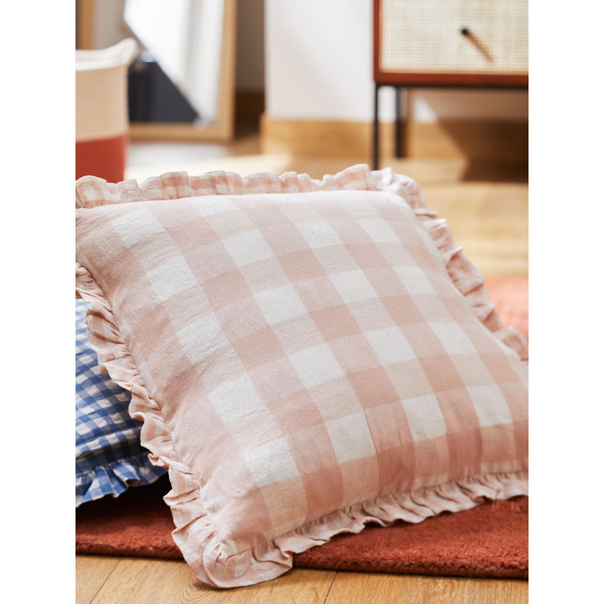 Pink gingham cushion on floor John Lewis