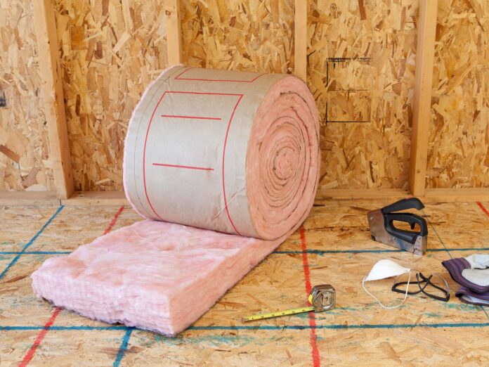 Roll of fiberglass insulation in an unfinished room. 