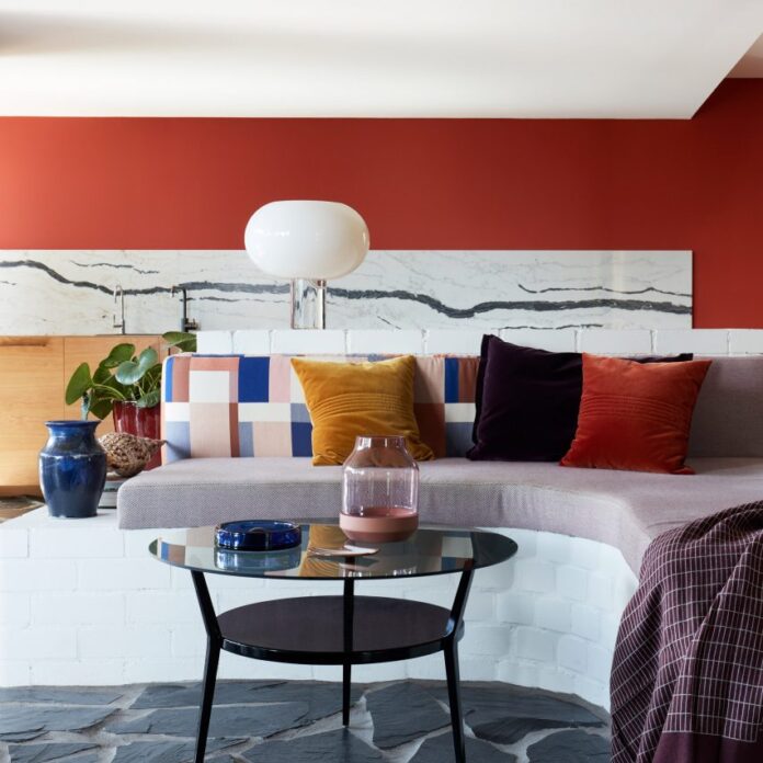 Living room with red wall and colourful pillows