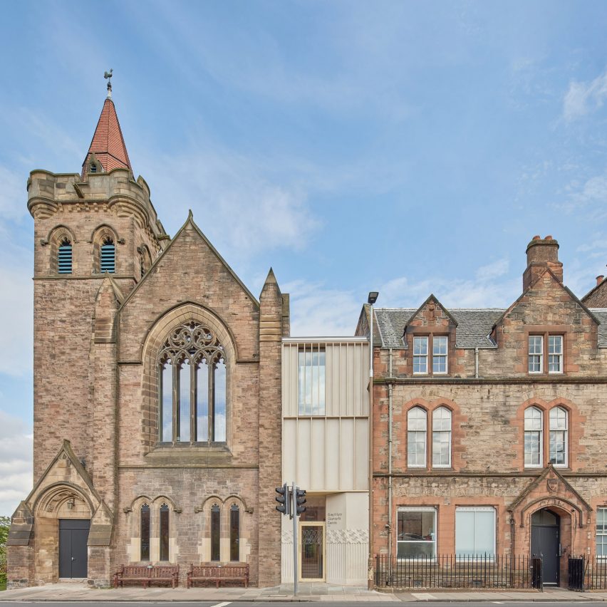 Photograph showing slim timber link building between two stone buildings