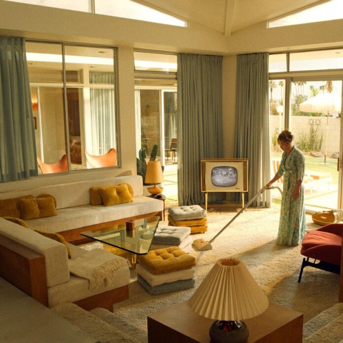 A woman hoovering in a living room