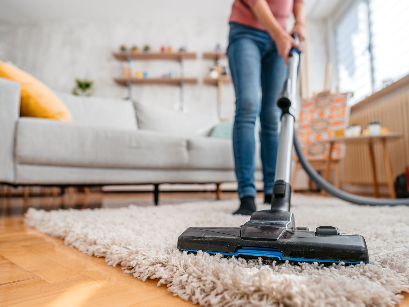 Person vacuuming rug at home