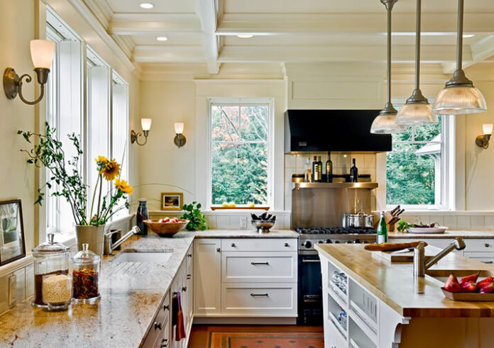 Traditional kitchen and island with recessed lighting over the countertops.