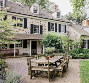 Colonial stone home with black window shutters