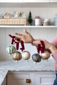 Christmas ornaments made using wallpaper and velvet ribbon.