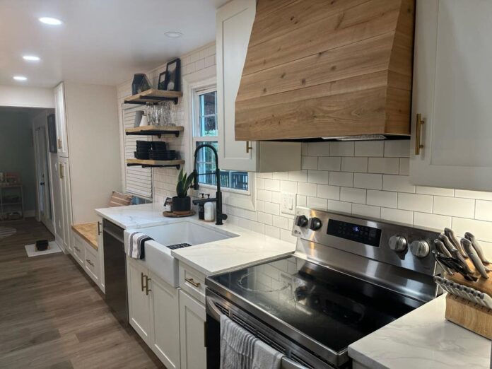 White shaker kitchen with pine wood hood and light gray island cabinets