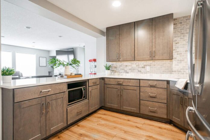 Warm wood shaker kitchen cabinets in a basement bar with tile backsplash